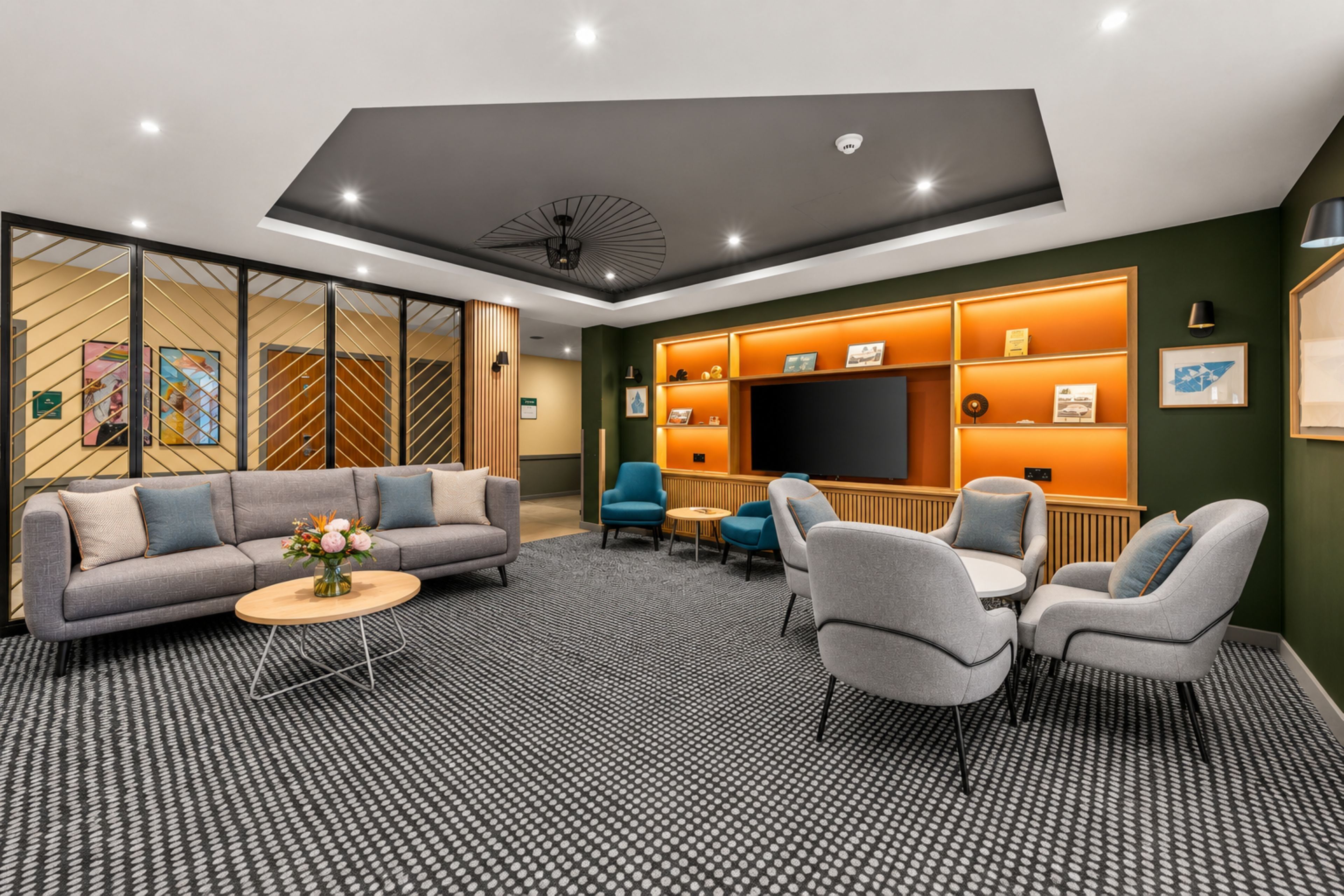 Una sala de estar moderna con un sofá, sillones, una mesa de centro y un televisor.