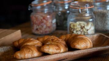 A wooden tray with croissants and jars of ingredients.