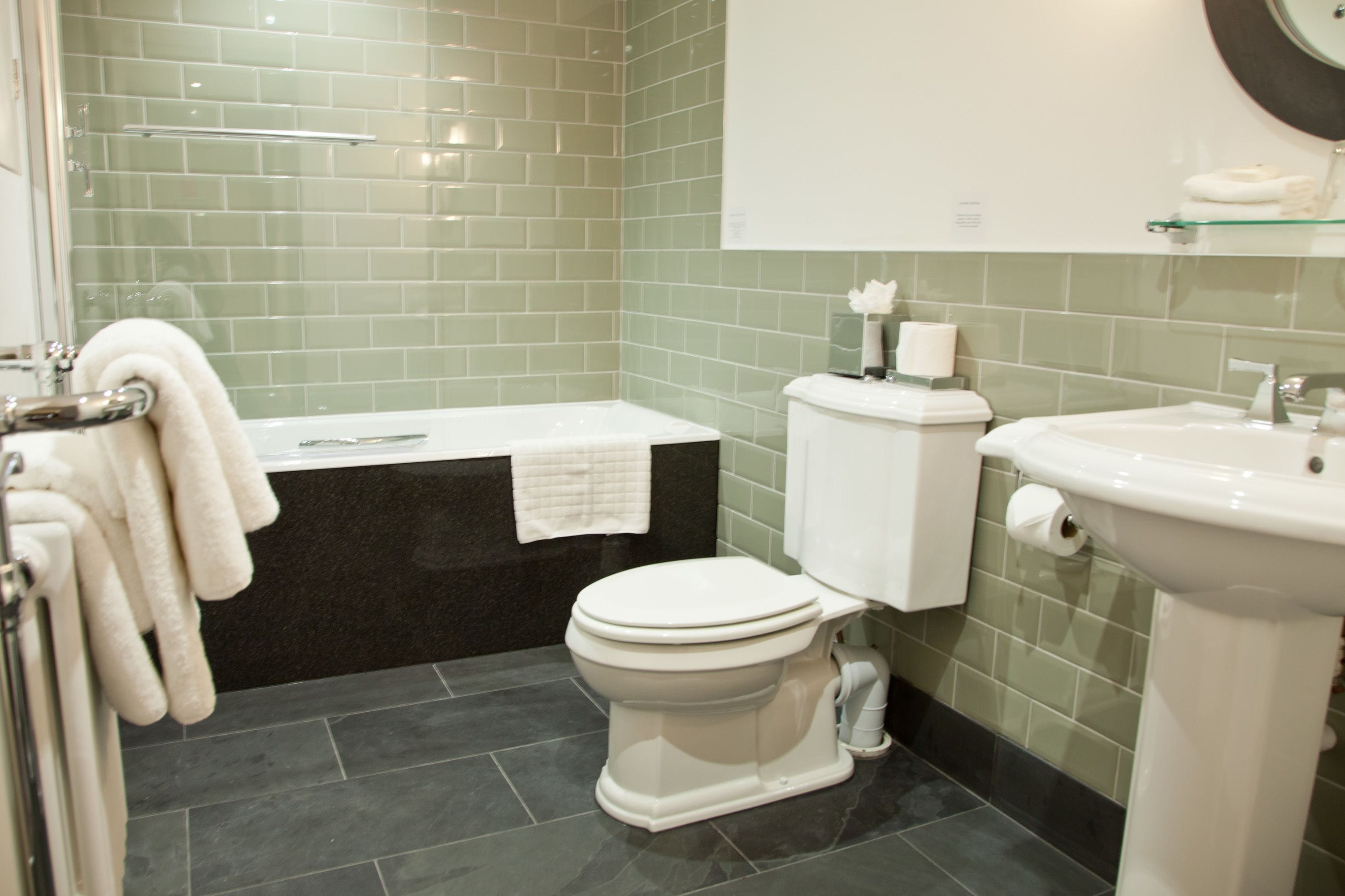 A bathroom with a toilet, bathtub, and sink.