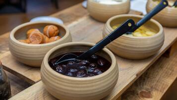 A wooden table with several ceramic bowls containing different foods.