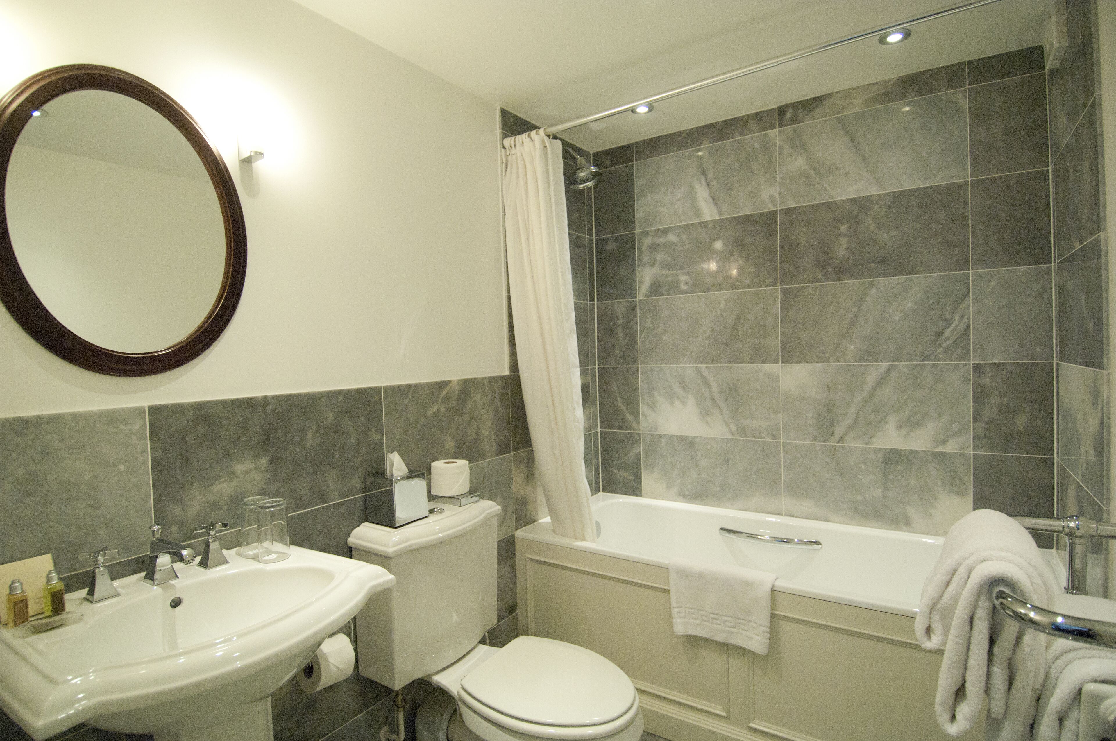 Een badkamer met een wastafel, toilet, bad en douchegordijn.