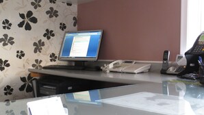 A reception desk with a computer, a telephone, and a fax machine. - Kings Inn Midland (Midland)