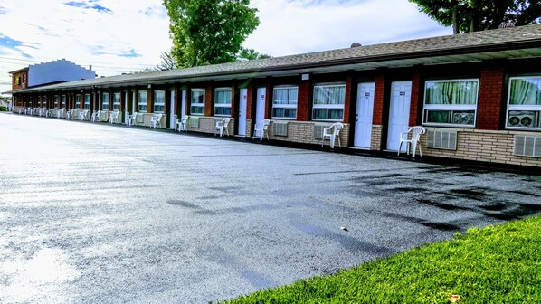 Un motel con una hilera de habitaciones, cada una con ventana y puerta.