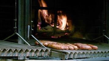 A grill with sausages being cooked over an open flame.