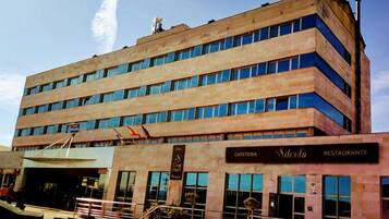 A multi-story building with a cafe and restaurant on the ground floor.