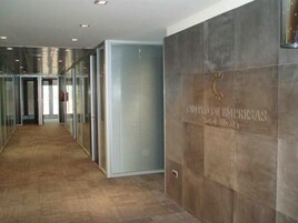 A hallway with a glass wall, a closed door, and a sign reading "CENTRO DE EMPRESAS Hotel S.M. de Vitoria".