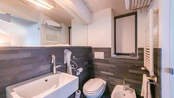 Un bagno moderno con una vasca da bagno ampia, un water e un bidet.