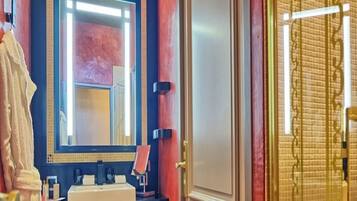 A bathroom with a large mirror, a sink, and a towel rack.