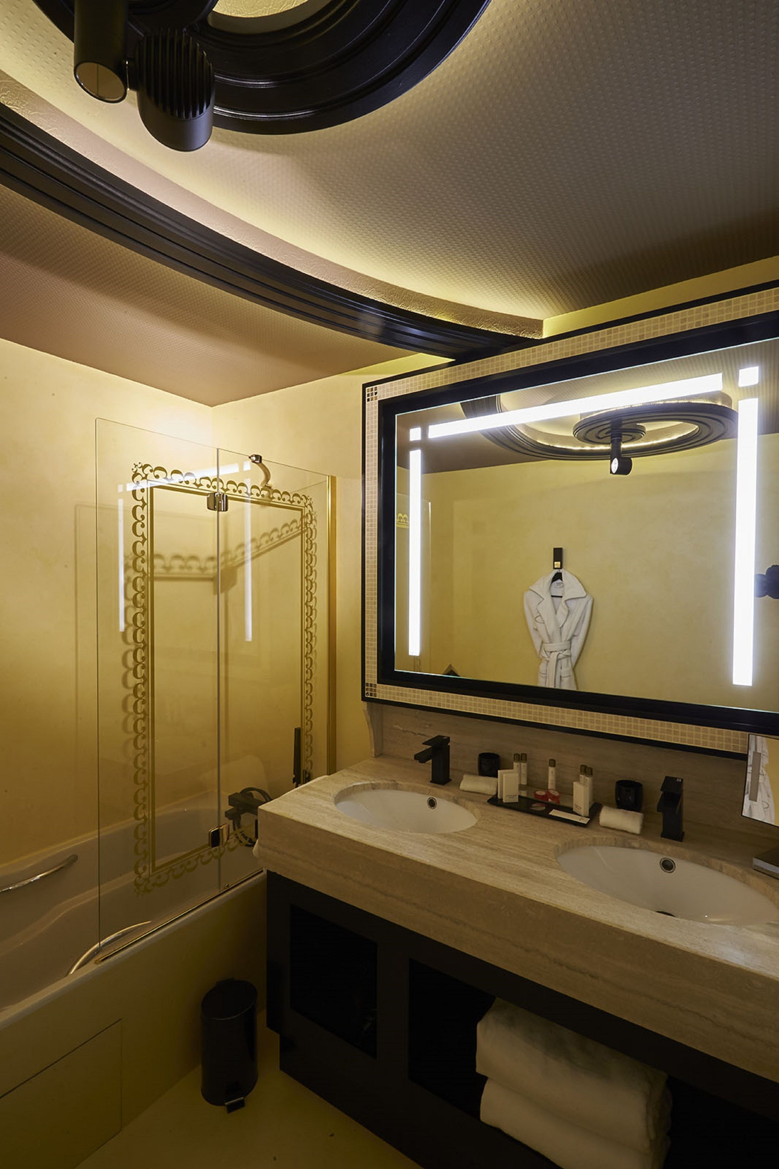 A bathroom with two sinks, a large mirror, and a shower enclosure.