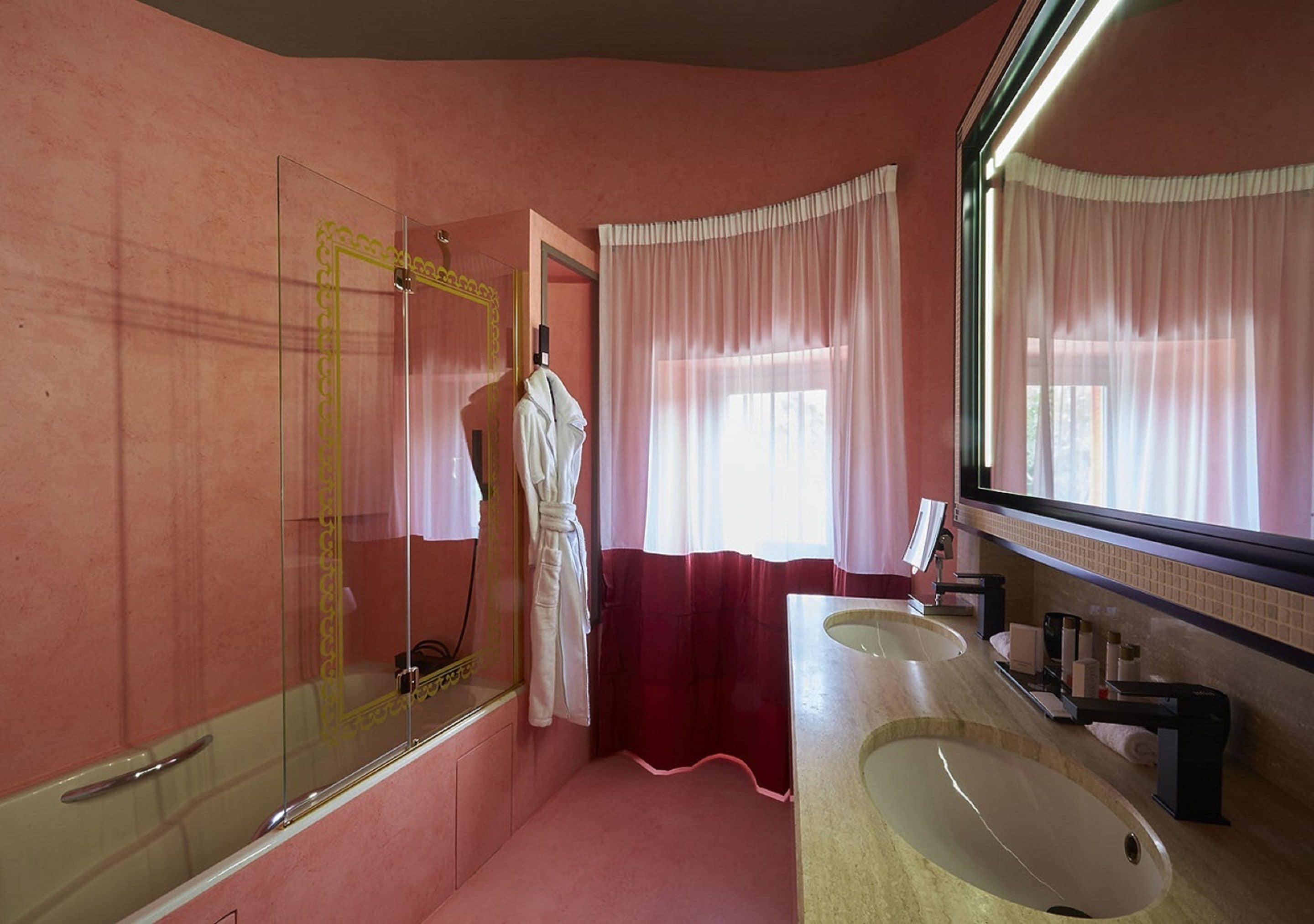 A bathroom with a large mirror, two sinks, and a shower.