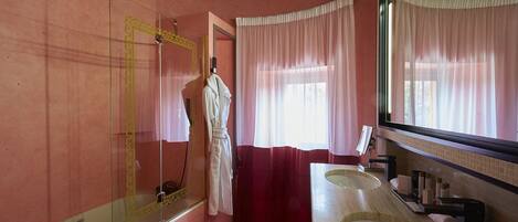 A bathroom with a large mirror, two sinks, and a shower.