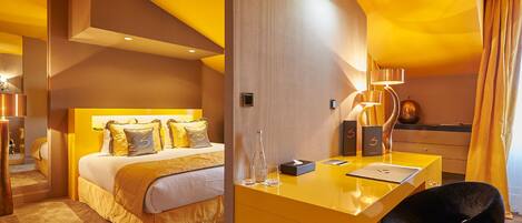 A modern hotel room with a large bed, a desk, and a chair.