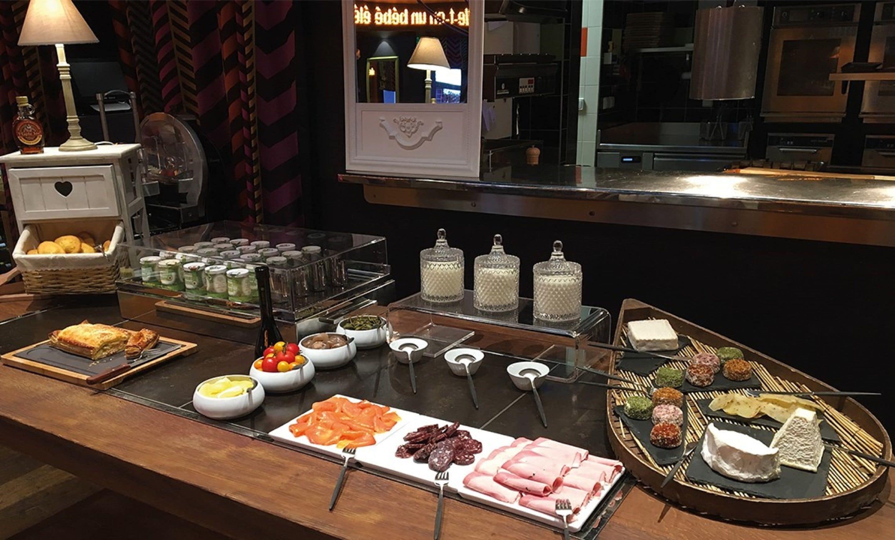 Un buffet con un'ampia scelta di cibi, tra cui dolci, carni, formaggi e salse.