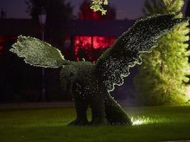 Escultura de jardim de um pássaro com asas abertas.