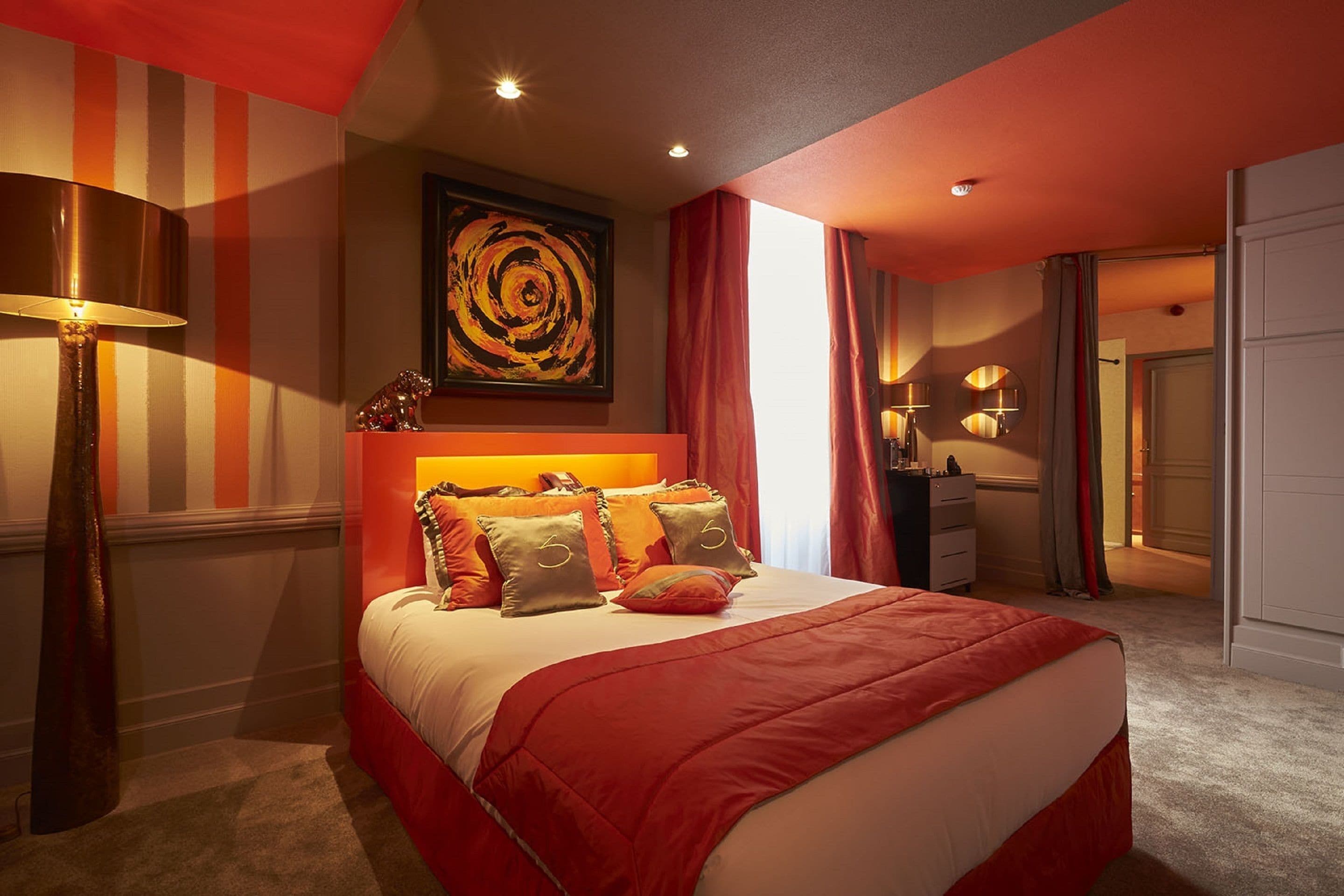 Una camera d'albergo con un letto grande, un quadro appeso al muro e vista all'esterno.