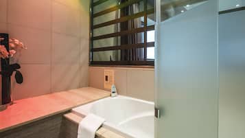 Un baño moderno con una bañera independiente, una cabina de ducha de vidrio y una encimera de mármol.