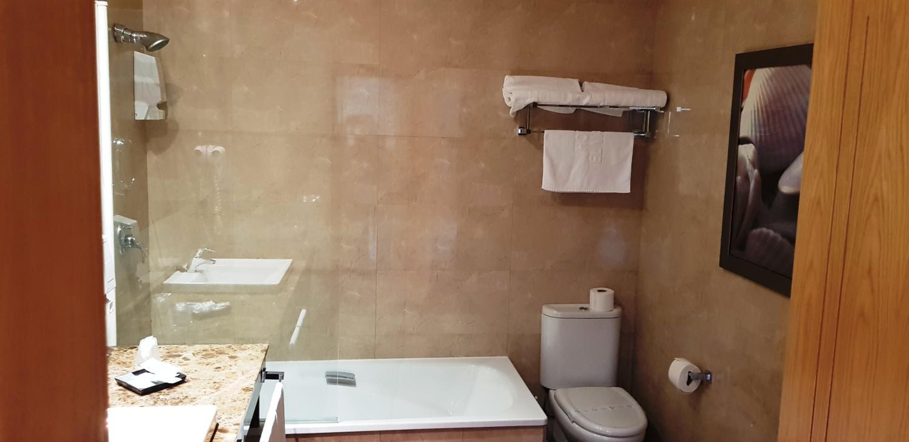 Casa de banho com banheira, sanita e lavatório.