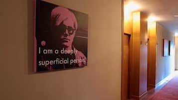 A hallway with a poster on the wall and wooden doors.