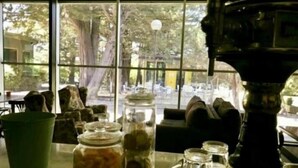 A room with a large window, a table with jars and a coffee maker, and a couch. - Hotel El Vallés (Briviesca)
