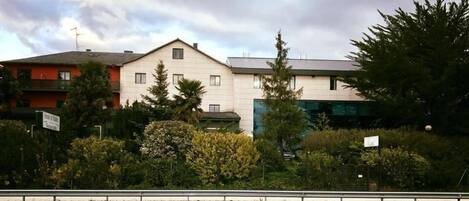 Un edificio de dos plantas con techo plano y varias ventanas.