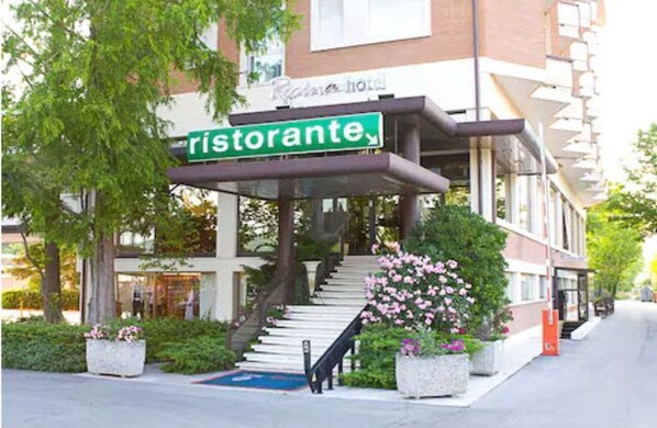 Entrada de un hotel con un letrero que dice "ristorante" y una escalera que lleva a la entrada.