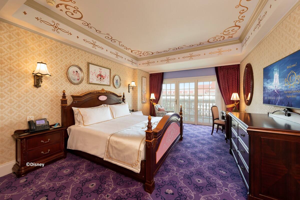 Ein Hotelzimmer mit einem großen Bett, einem Schreibtisch, einem Stuhl und einem Fernseher.