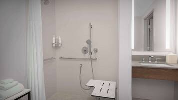 Un baño moderno con ducha, lavamanos y espejo.