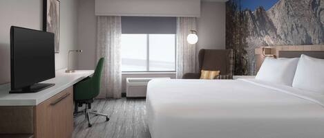 A hotel room with a bed, desk, chair, TV, and a large window with curtains.