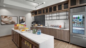 Una cocina moderna con armarios de madera, salpicadero de mármol y un refrigerador empotrado.