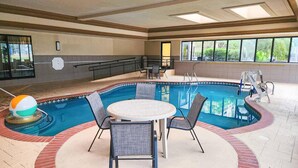 An indoor swimming pool with a round table and chairs, a lifeguard stand, and a beach ball. - Country Inn & Suites by Radisson, Tyler University Area (Tyler)