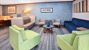 Un hall d’hôtel moderne doté d’un espace salon, d’un bureau et d’un coin café.