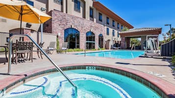 Relax by the pool surrounded by lounge chairs and umbrellas.