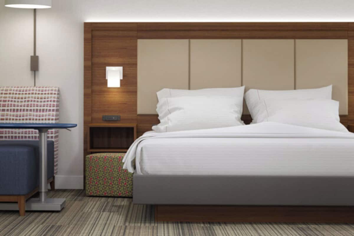 A hotel room with a large bed, bedside tables, a desk, and a chair.