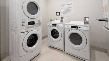 A laundry area with multiple washing machines and a sign indicating it's for guest use.