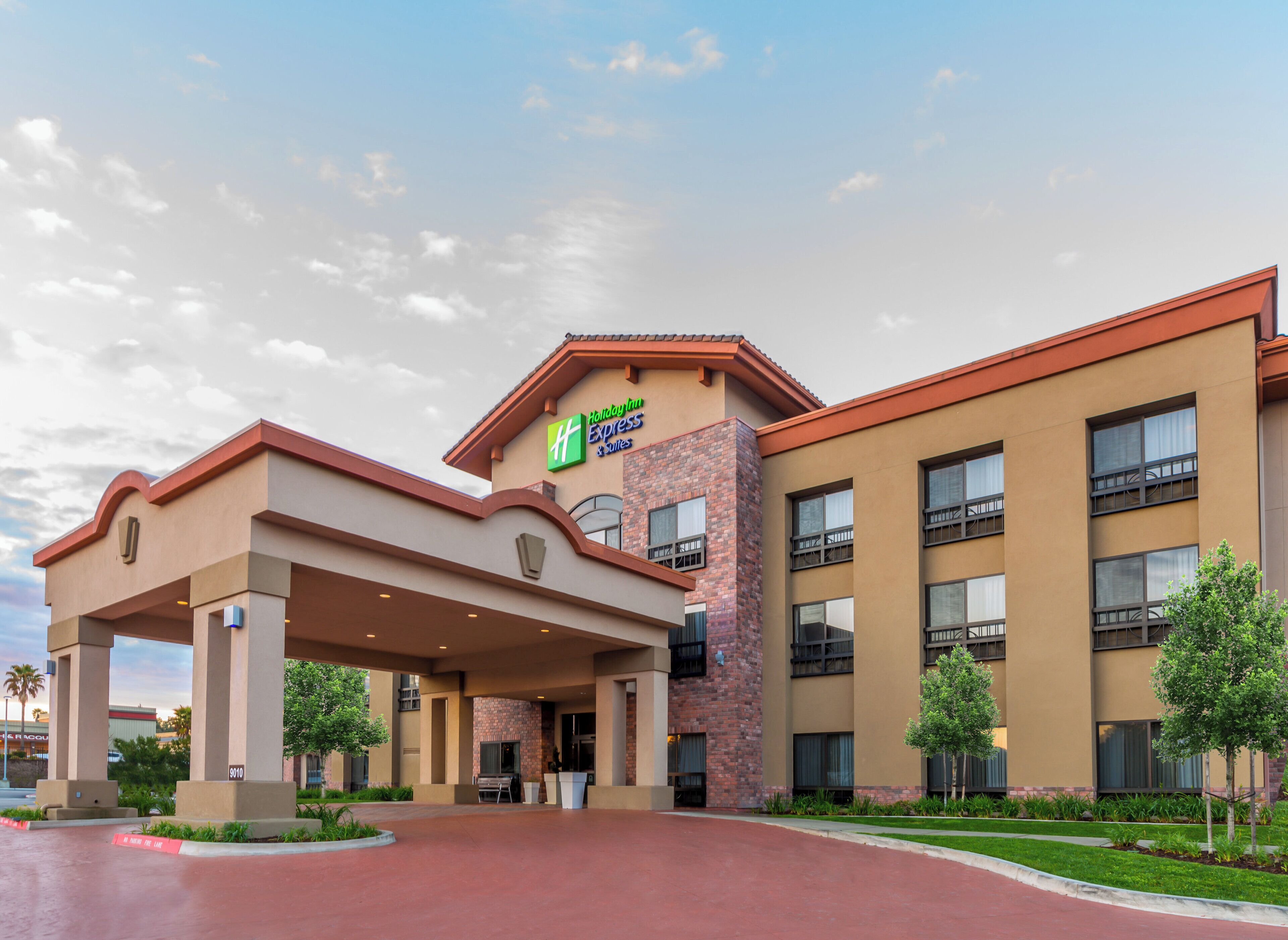 Un hotel Holiday Inn Express con facciata in mattoni, diversi balconi e un'area d'ingresso coperta.