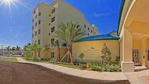 A hotel with a modern design, featuring a prominent entrance with a blue roof and a sign that reads "Homewood Suites."