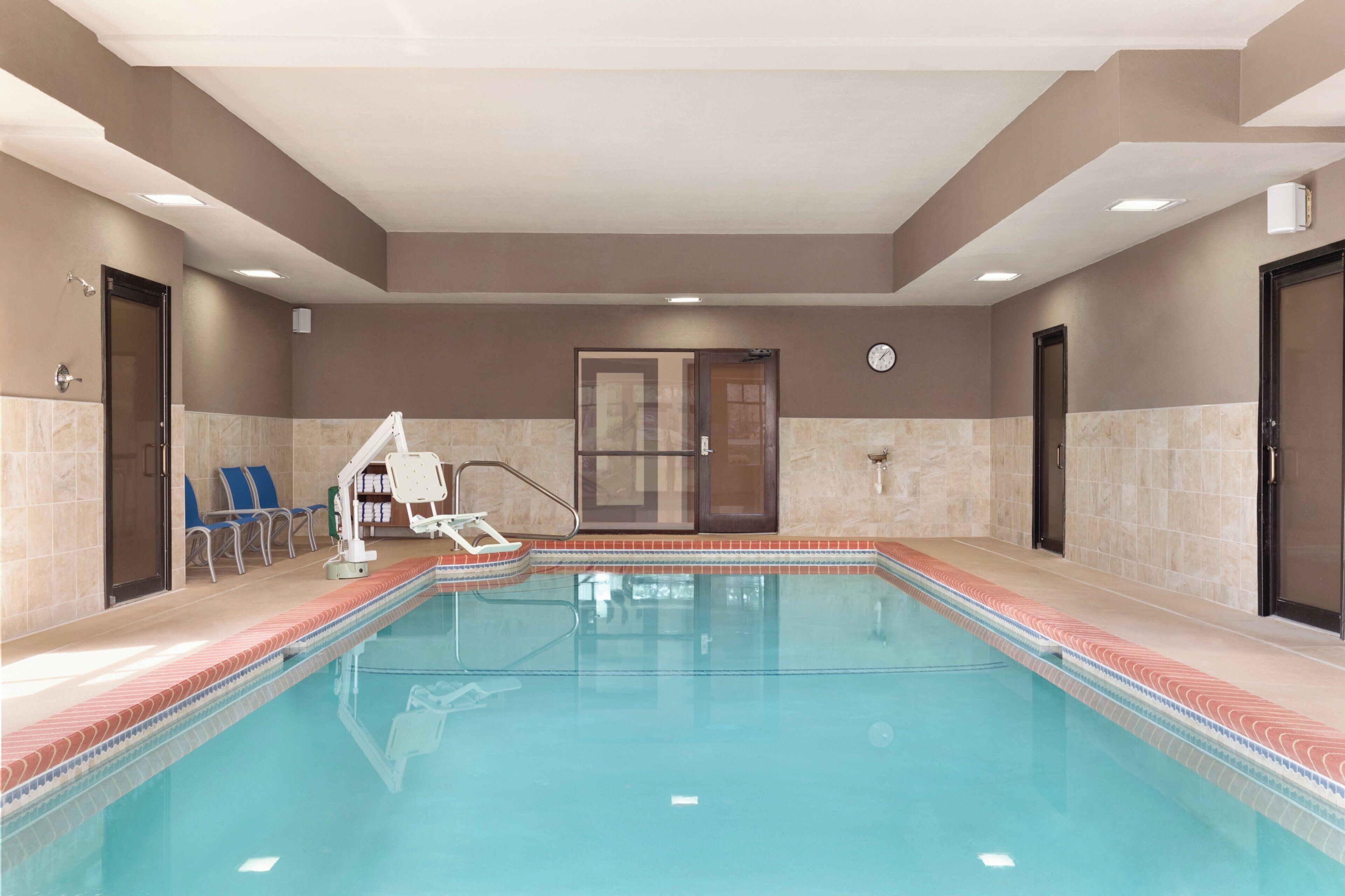 A swimming pool with a lifeguard chair, a changing room, and a door.