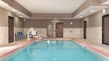 A swimming pool with a lifeguard chair, a changing room, and a door.