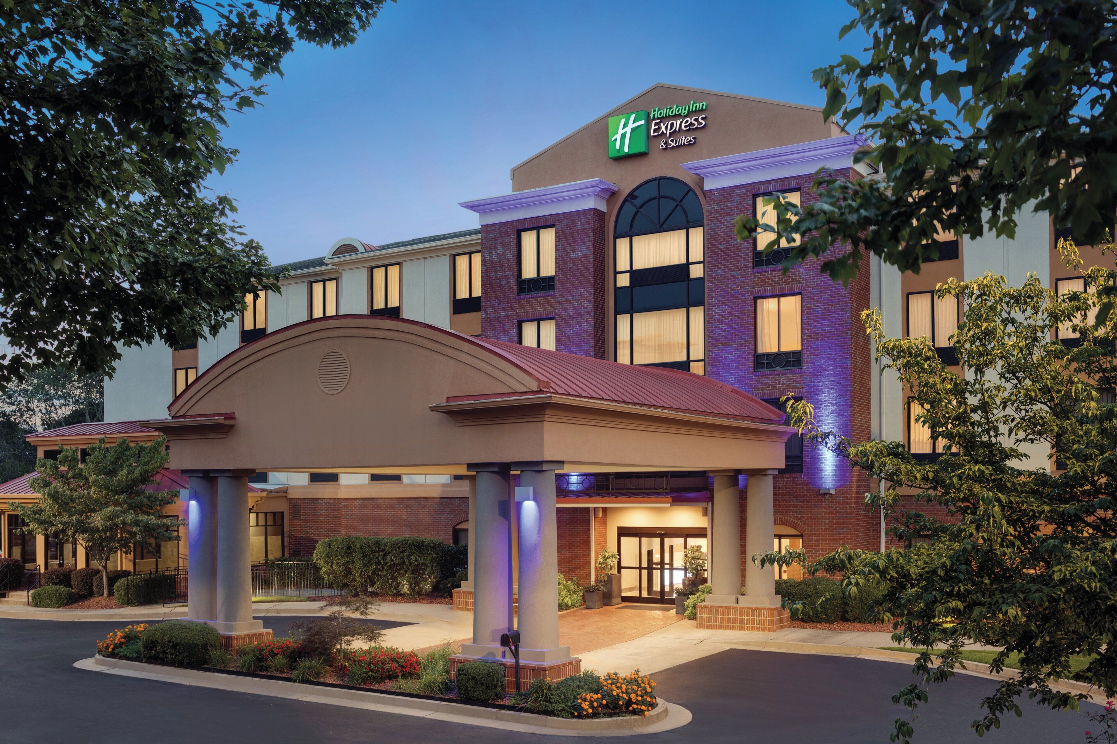 Edificio de Holiday Inn Express & Suites con fachada de ladrillo, ventanas grandes y una zona de entrada cubierta.
