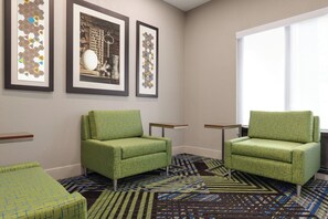 A room with two green armchairs, a patterned carpet, and three framed artworks on the wall. - Holiday Inn Express Hotel & Suites Lavonia by IHG (Lavonia)