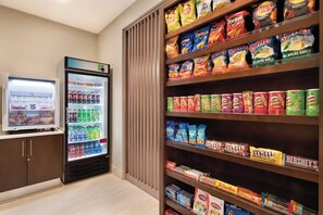 A snack and beverage display area with a variety of chips, sodas, and a refrigerator stocked with drinks. - Holiday Inn Express Hotel & Suites Lavonia by IHG (Lavonia)