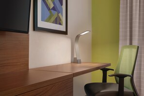 A desk with a modern lamp, a framed abstract painting, and a green chair. - Holiday Inn Express Hotel & Suites Lavonia by IHG (Lavonia)