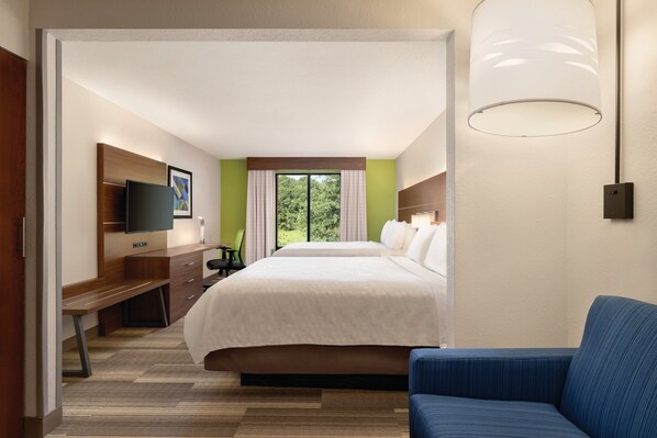 A hotel room with a large bed, a desk with a chair, a TV mounted on the wall, and a window with curtains. - Holiday Inn Express Hotel & Suites Lavonia by IHG (Lavonia)