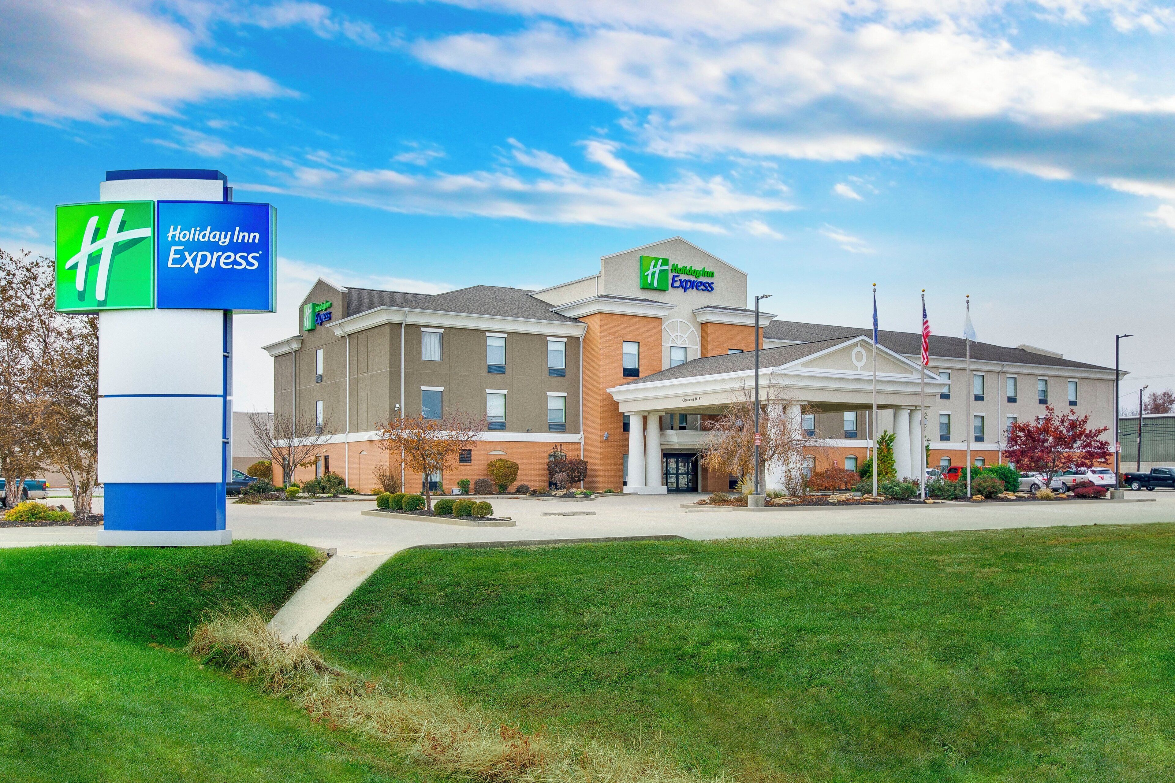 A Holiday Inn Express hotel with a clear entrance, a parking lot, and a well-maintained lawn.