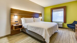 A modern hotel room with a large bed, a bedside table, a chair, and a window with a view. - Holiday Inn Express Vincennes by IHG (Vincennes)