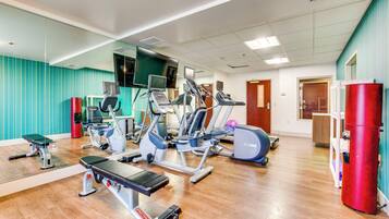A gym with various exercise equipment, including treadmills, stationary bikes, and weight machines.