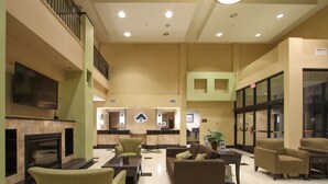A spacious lobby with a fireplace, seating area, and a reception desk. - GreenTree Inn & Suites Florence (Florence)