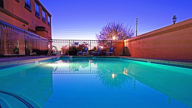 A swimming pool with a clear view of the surrounding area, including a building with balconies and a fence. - GreenTree Inn & Suites Florence (Florence)