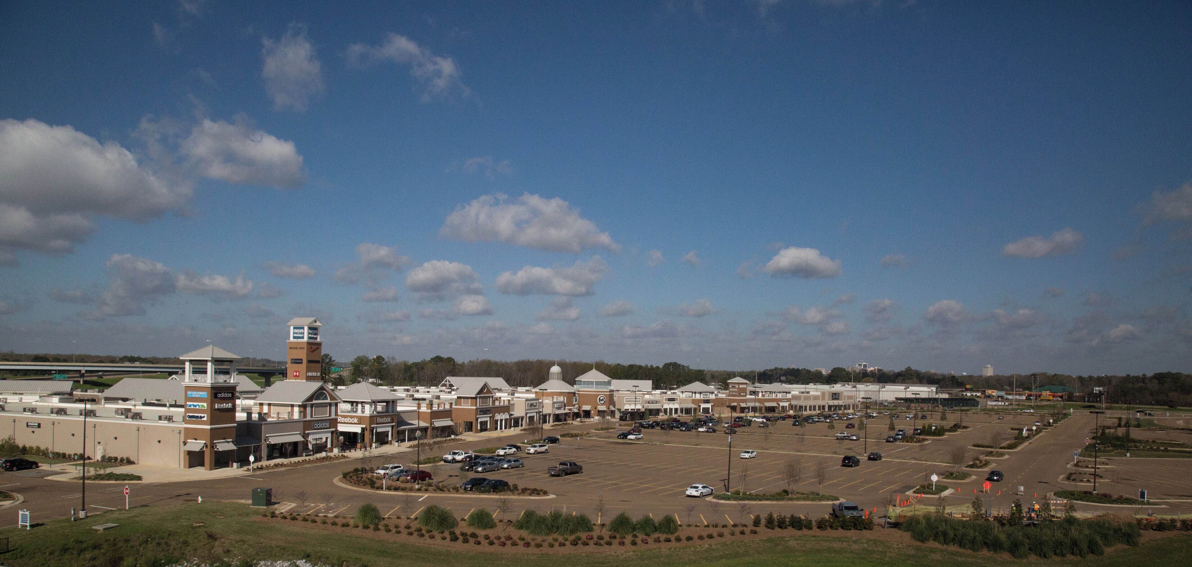 A large parking lot with multiple buildings, including a tall structure with a clock tower.