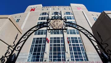 A building with a large arched entrance, a prominent 'N' logo, and a quote on the lower part of the entrance.